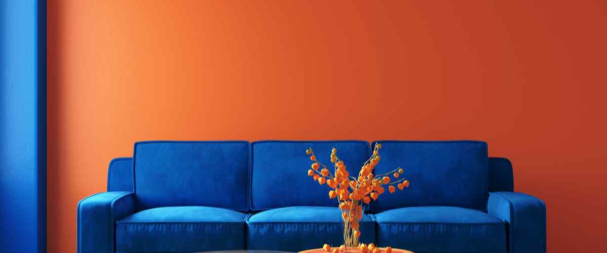 Royal blue couch and orange wall decor