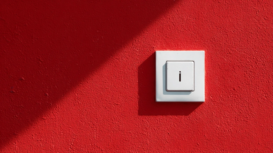 Minimalist white square switch on a vibrant red textured wall
