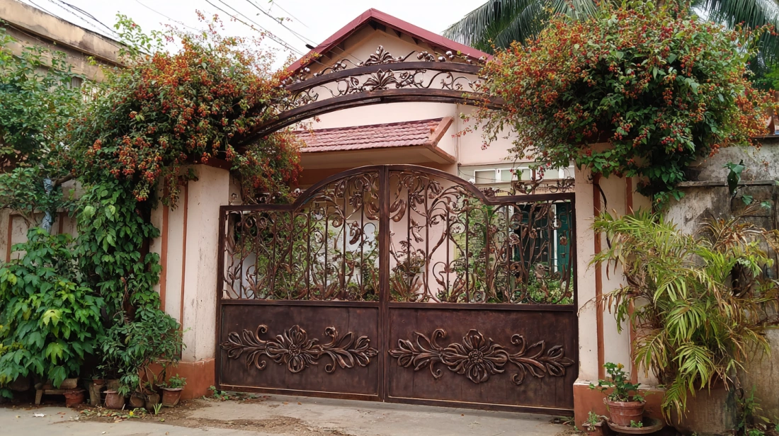 Ornate deep green iron gate with intricate floral metalwork