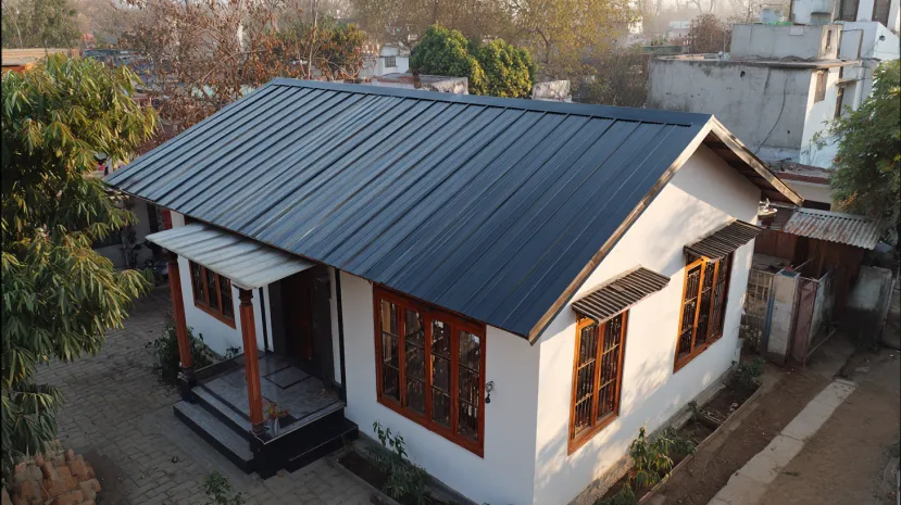 Dark grey metal sheet roof design on a suburban cottage.