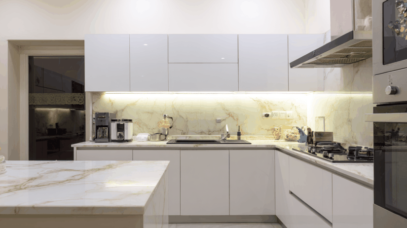 White granite countertops with white cabinets in a modern Indian modular kitchen