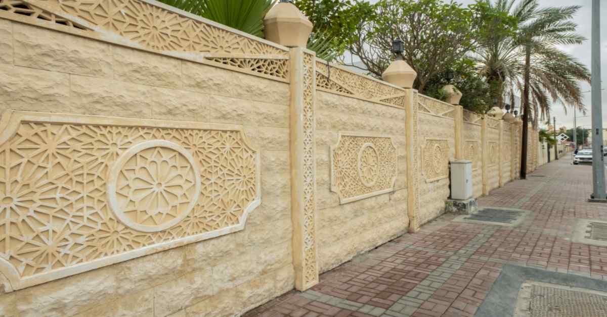 Decorative ornamental boundary wall with intricate stone carvings